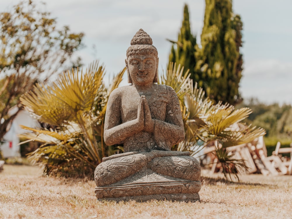 statue bouddha assis namaste robe fleurs jardin extérieur en pierre volcanique naturelle 100cm