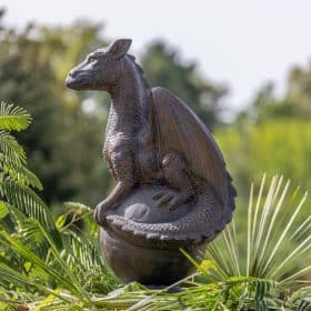 Statue of a dragon on a sphere in antique black reconstituted stone 85cm