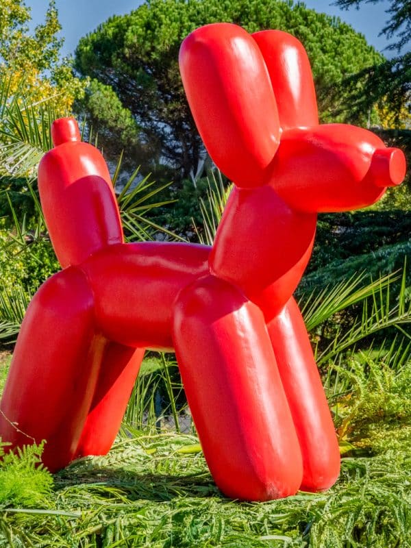 Statue chien ballon rouge en pierre reconstituée face